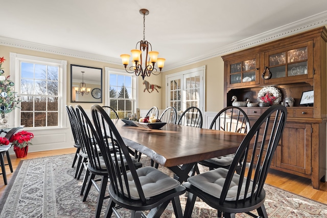 dining space with a notable chandelier, light hardwood / wood-style flooring, and ornamental molding