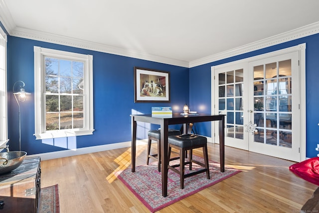 dining space featuring hardwood / wood-style flooring, french doors, and ornamental molding