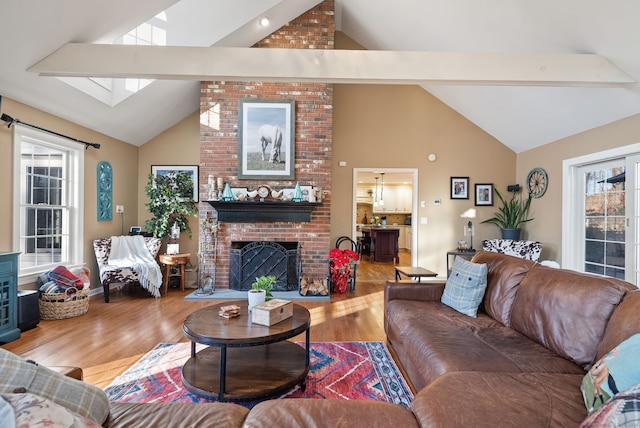 living room with high vaulted ceiling, plenty of natural light, and hardwood / wood-style flooring