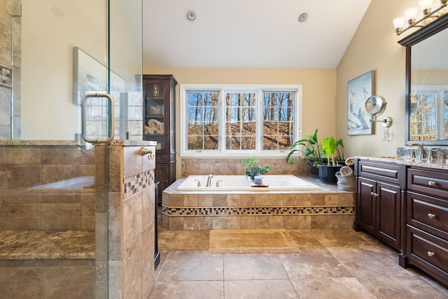 bathroom featuring tile patterned flooring, lofted ceiling, separate shower and tub, and vanity