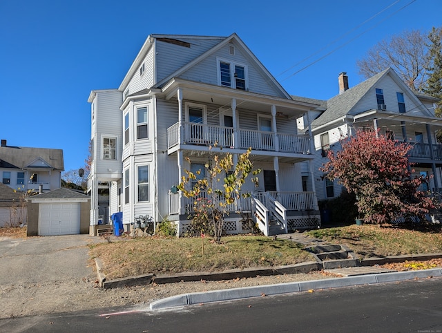 view of front of house with an outbuilding, a garage, covered porch, and a balcony