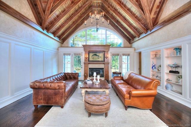 living room with built in shelves, high vaulted ceiling, a notable chandelier, and wood-type flooring