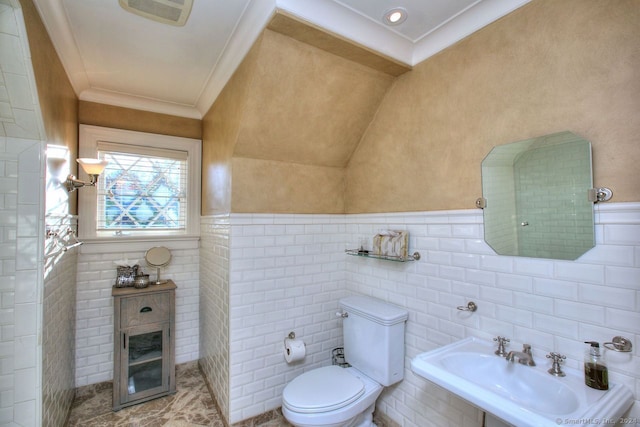 bathroom featuring toilet, ornamental molding, sink, and tile walls