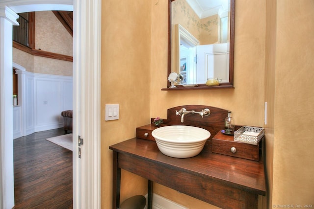 bathroom with hardwood / wood-style floors, ornamental molding, and sink