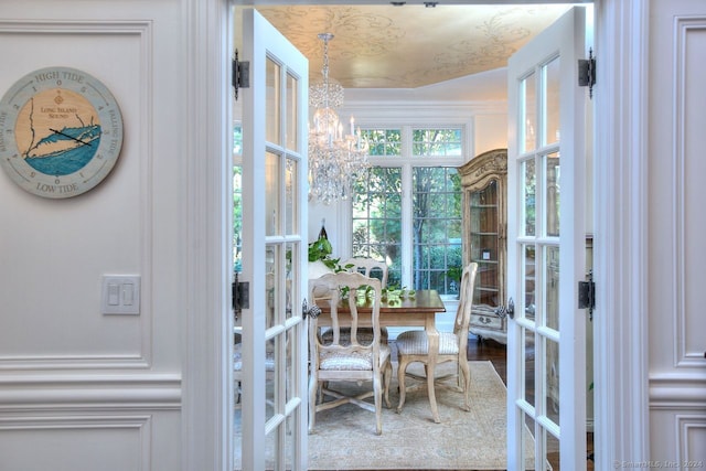 doorway with french doors, a notable chandelier, and wood-type flooring