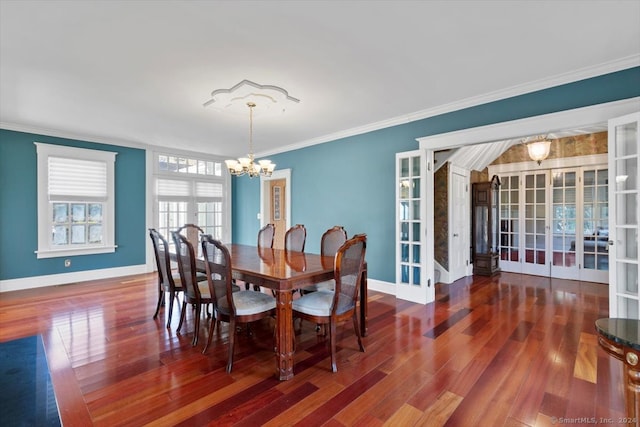 dining area with dark hardwood / wood-style floors, a chandelier, french doors, and ornamental molding