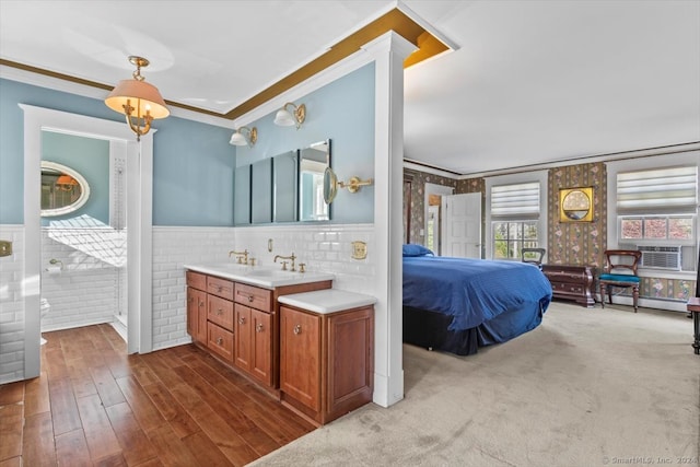 bathroom with a baseboard radiator, tile walls, hardwood / wood-style floors, vanity, and crown molding