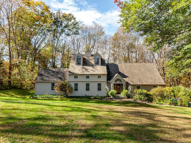 new england style home featuring a front lawn