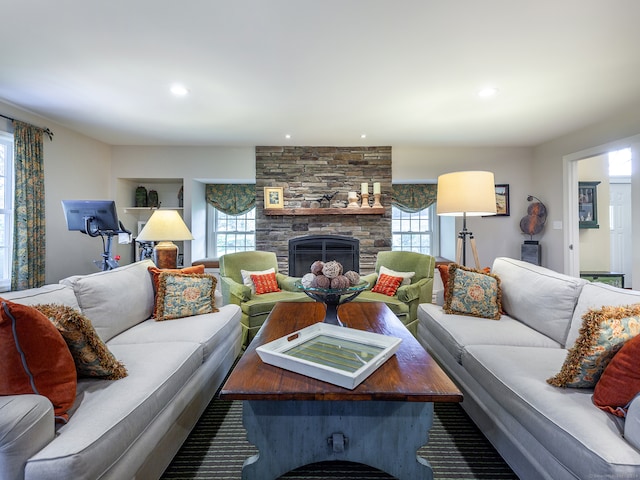 living room with a stone fireplace and a wealth of natural light