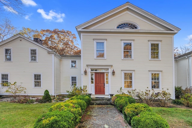 greek revival house featuring a front yard