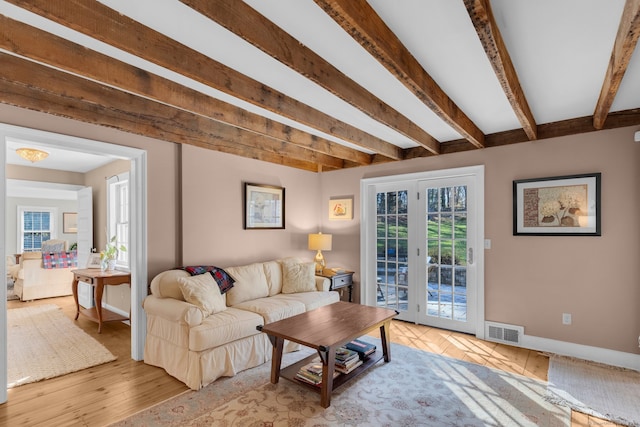 living room featuring french doors, light hardwood / wood-style flooring, and beam ceiling