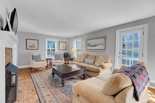 living room with a fireplace, hardwood / wood-style flooring, and plenty of natural light