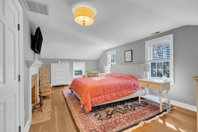 bedroom featuring light wood-type flooring and vaulted ceiling