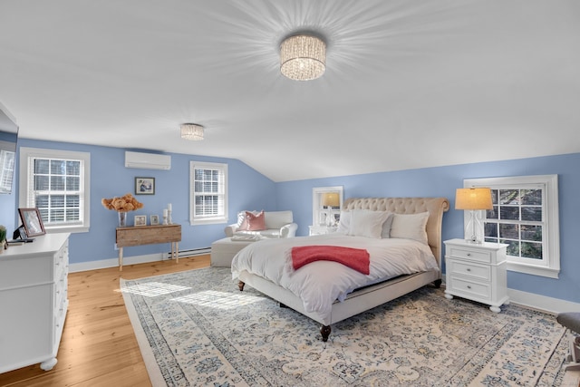 bedroom featuring light hardwood / wood-style floors, a wall mounted AC, and multiple windows