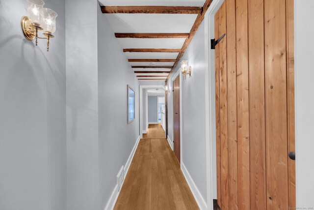 corridor featuring wood-type flooring and beam ceiling