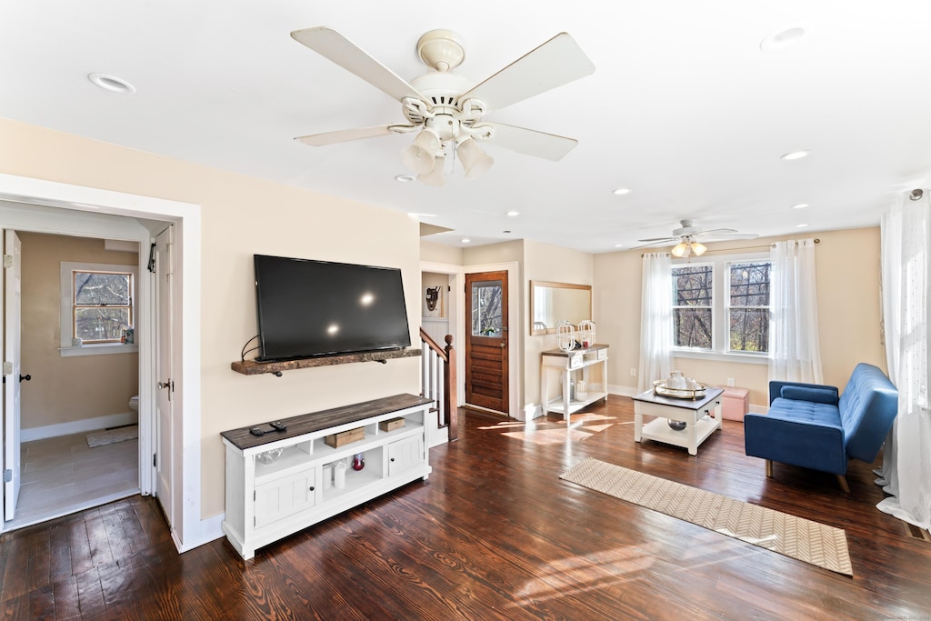 living room featuring ceiling fan and dark hardwood / wood-style flooring