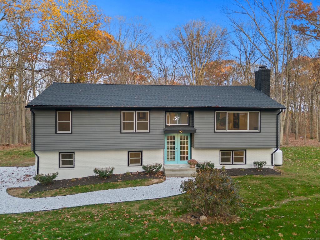 raised ranch with french doors and a front lawn