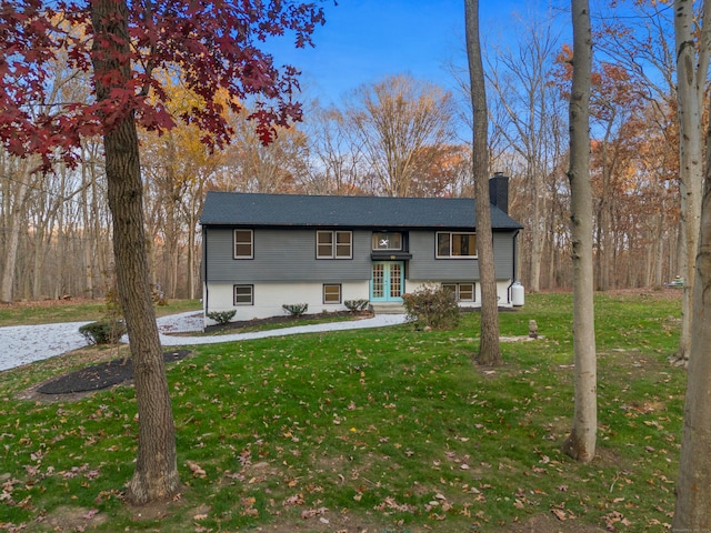 bi-level home with a front lawn and french doors