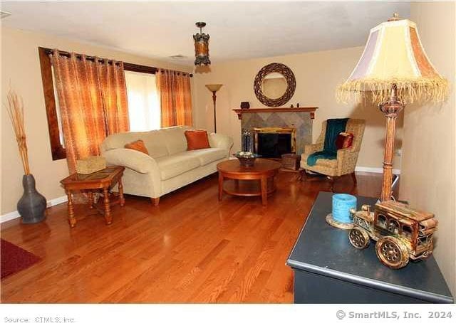 living room featuring hardwood / wood-style flooring and a premium fireplace