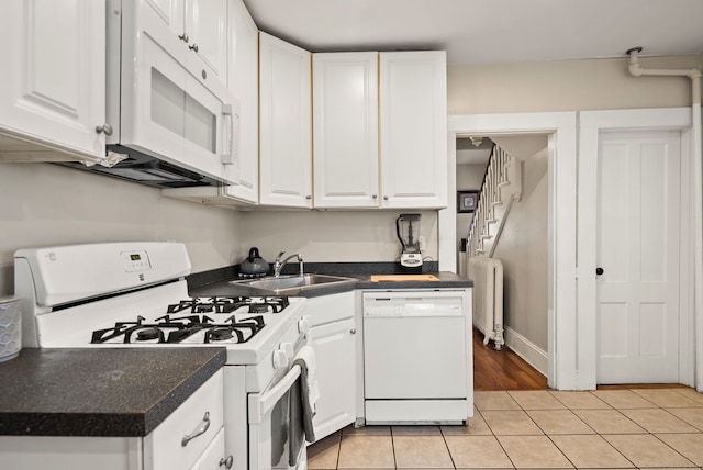 kitchen featuring white cabinets, white appliances, and radiator