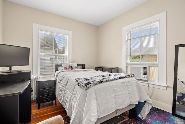 bedroom with cooling unit and dark hardwood / wood-style flooring