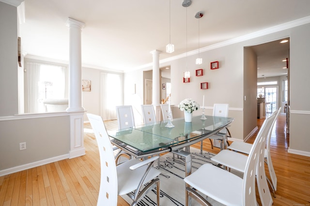 dining space with baseboards, ornate columns, and hardwood / wood-style floors