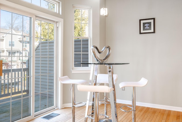 dining space with visible vents, baseboards, and hardwood / wood-style floors