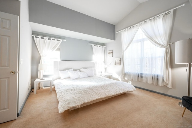 bedroom with light colored carpet, baseboards, and vaulted ceiling