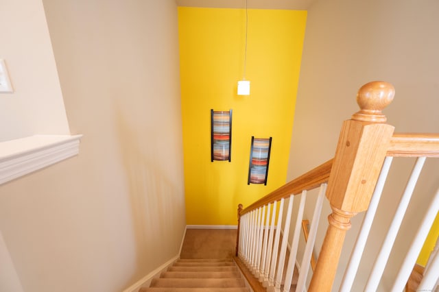 stairway with baseboards and carpet flooring