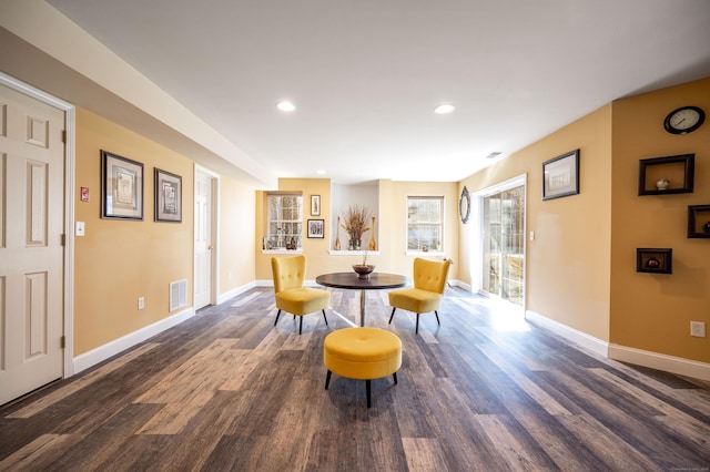 living area featuring visible vents, baseboards, and dark wood-style flooring