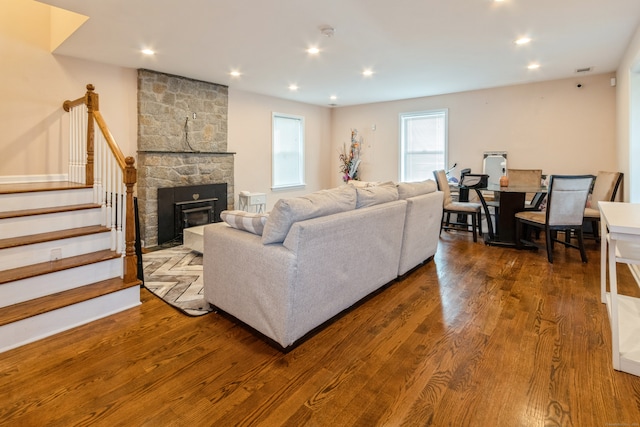 living room featuring a stone fireplace and hardwood / wood-style flooring