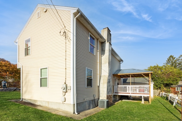 rear view of property featuring central air condition unit, a yard, and a deck