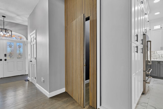 foyer entrance featuring light wood-type flooring, a chandelier, and a textured ceiling