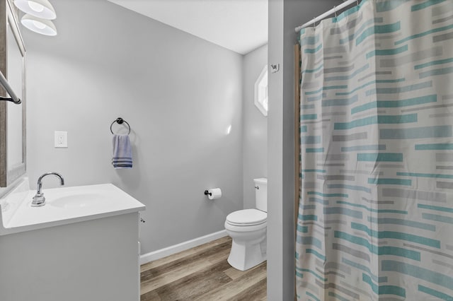 bathroom featuring curtained shower, wood-type flooring, toilet, and vanity