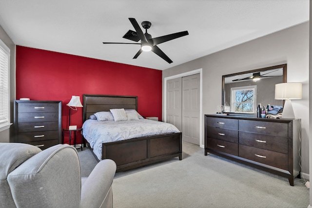 carpeted bedroom with ceiling fan and a closet