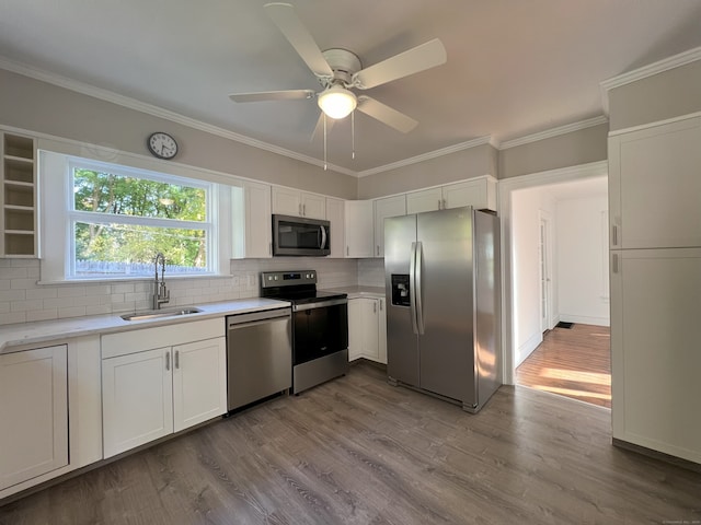 kitchen with white cabinetry, sink, light hardwood / wood-style floors, and appliances with stainless steel finishes