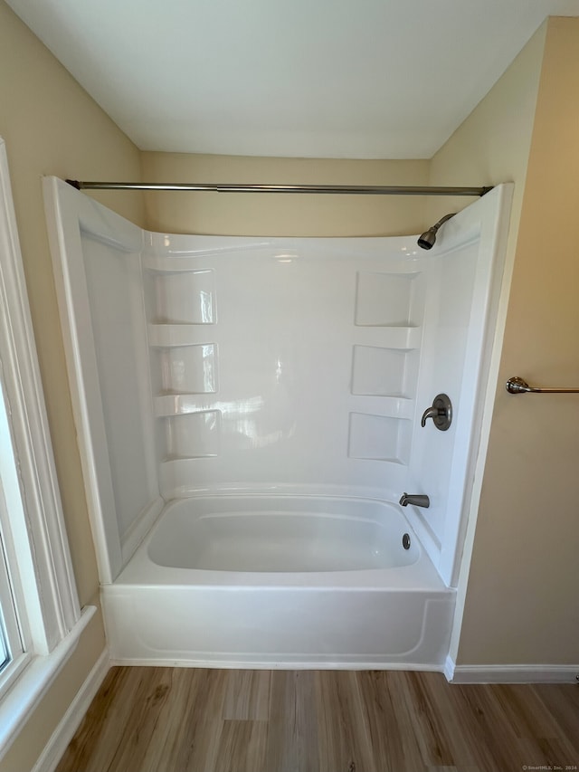 bathroom with hardwood / wood-style flooring and shower / tub combination