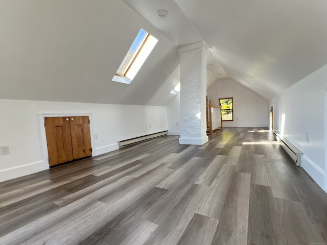 additional living space featuring hardwood / wood-style floors, vaulted ceiling, and baseboard heating