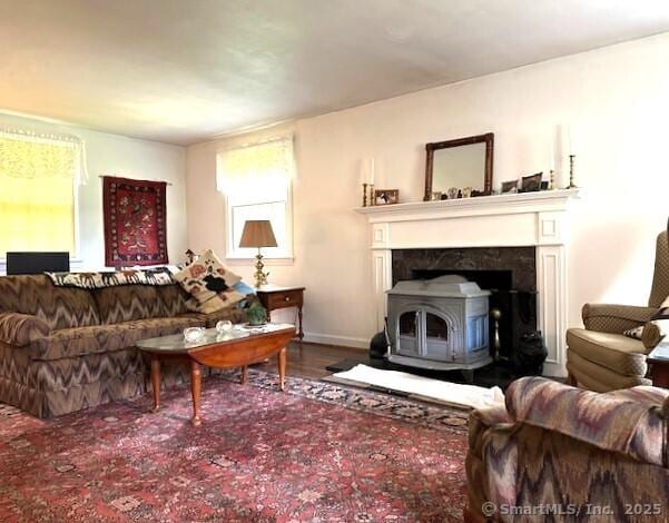 living room with baseboards, wood finished floors, and a wood stove