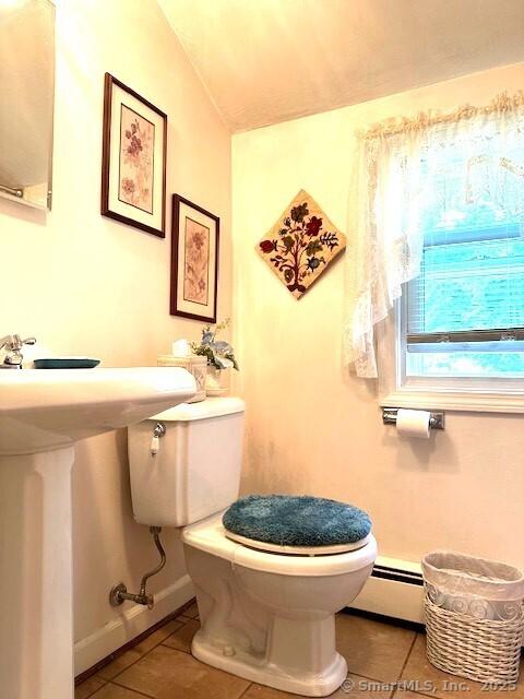 bathroom featuring toilet, tile patterned flooring, baseboards, baseboard heating, and vaulted ceiling