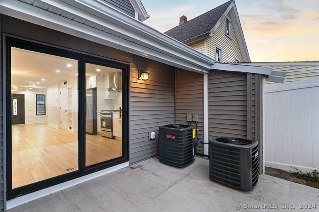 patio terrace at dusk featuring central AC unit