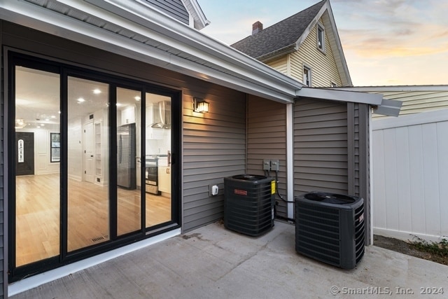 patio terrace at dusk featuring central AC unit