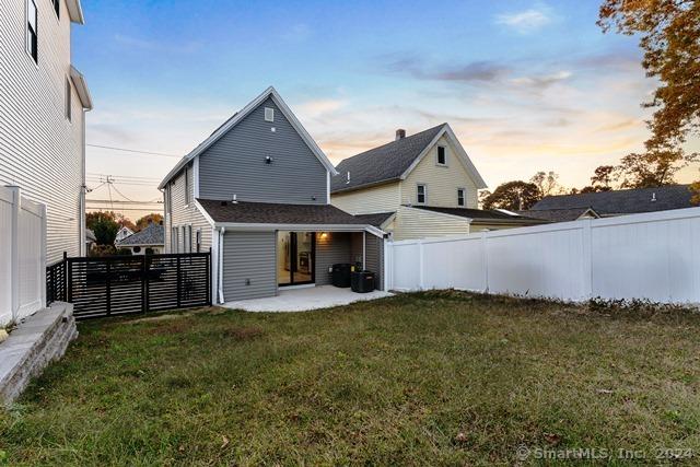 45 Stevens St, Milford, CT 06460 - back of house at dusk featuring a patio area