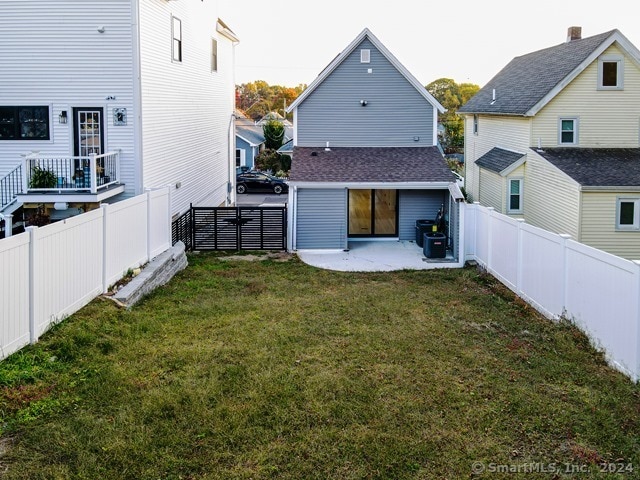 rear view of house featuring a patio and a yard