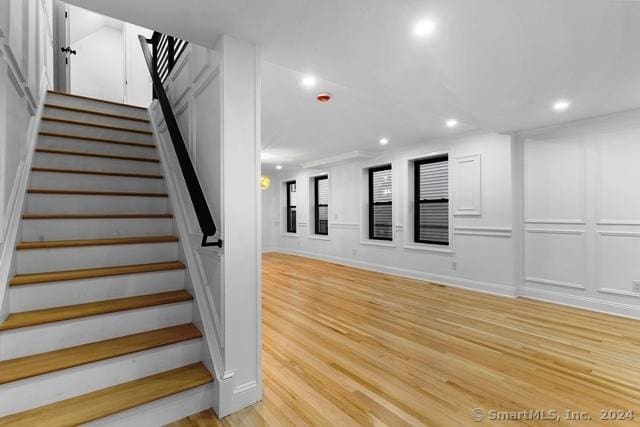 45 Stevens St, Milford, CT 06460 - stairway with recessed lighting, a decorative wall, and wood finished floors