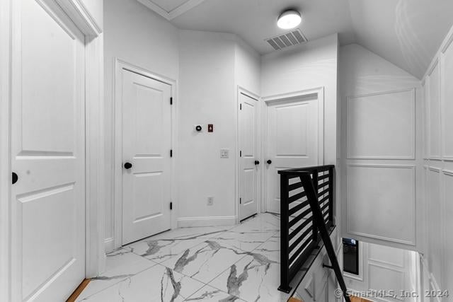 45 Stevens St, Milford, CT 06460 - corridor featuring light marble finish flooring, lofted ceiling, and baseboards