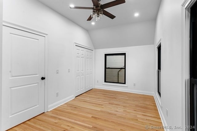 unfurnished bedroom with wood-type flooring, ceiling fan, and lofted ceiling