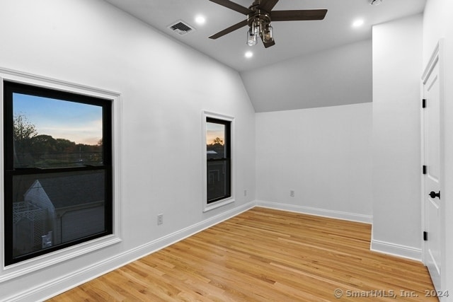 unfurnished room with hardwood / wood-style floors, ceiling fan, and vaulted ceiling