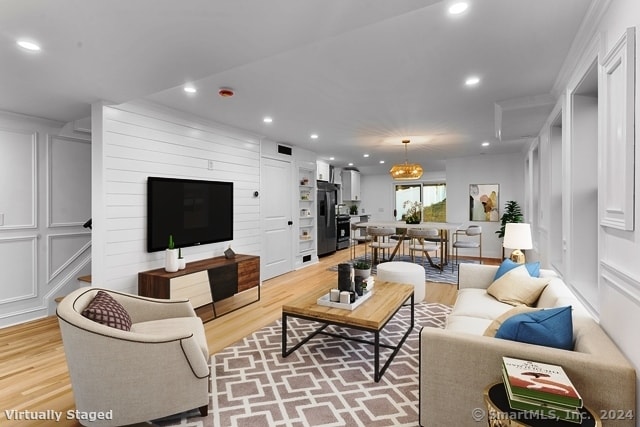 living room featuring light wood-type flooring and ornamental molding