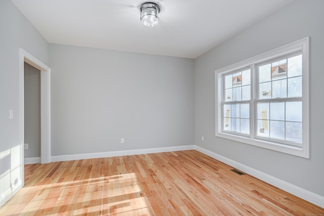 spare room featuring a healthy amount of sunlight and light hardwood / wood-style flooring